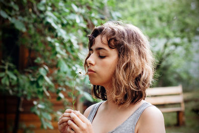 Teenager girl holding flower outdoors