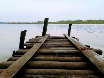 Wooden pier over lake against sky