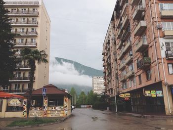 Cars on street in city against sky