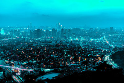 High angle view of illuminated cityscape against sky at night