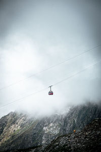 Low angle view of overhead cable car against sky