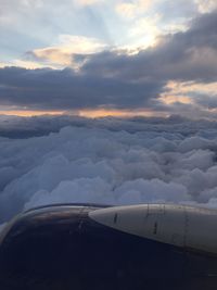 Close-up of airplane wing against cloudy sky