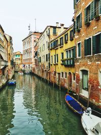 Boats in canal with buildings in background