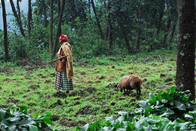 Side view of a man standing in forest