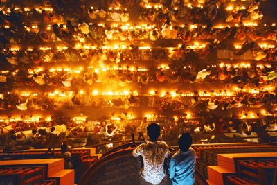 Rear view of couple standing at illuminated town