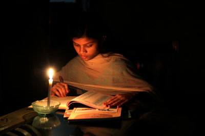 Young woman sitting on table at night