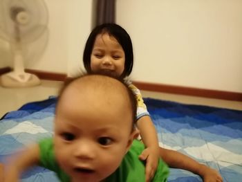 Portrait of cute baby on bed at home