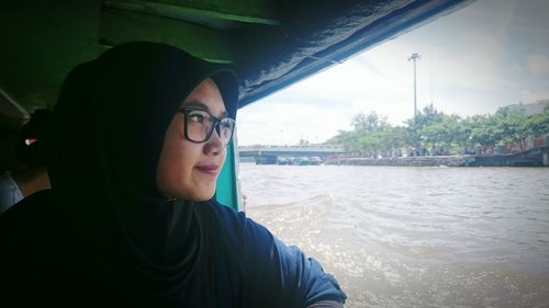 Portrait of young woman in sunglasses against sky