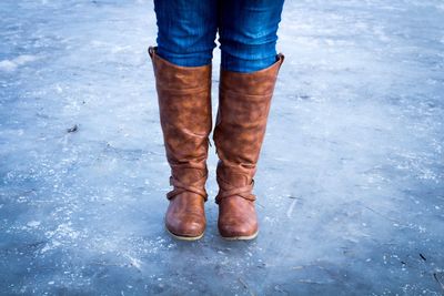 Low section of woman in boot standing on road