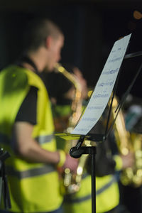 Sheet music on stand against musicians at brazzobrazzie festival