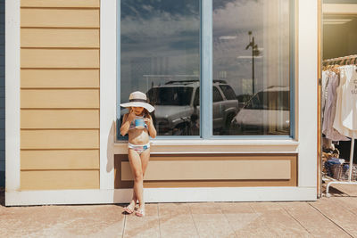 Girl eating ice cream in front of beachfront cafe