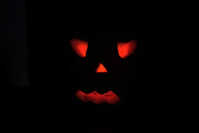 Close-up of illuminated pumpkin against black background