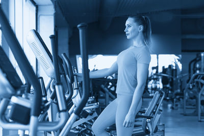 Portrait of young woman exercising in gym