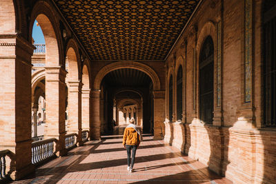Rear view of a man walking in historical building