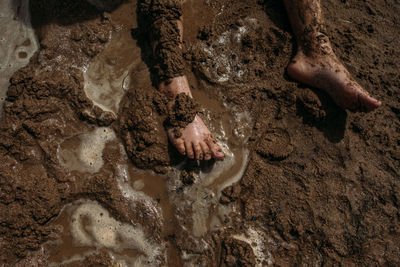 Young child's legs covered in mud