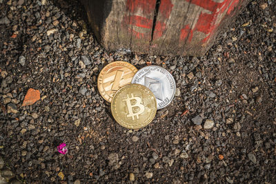 High angle view of coins on rock