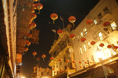 Low angle view of illuminated lanterns hanging in city at night