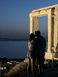 Rear view of couple looking at sea against sky