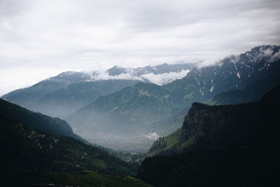 Scenic view of mountains against cloudy sky