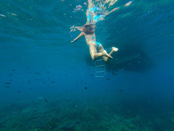 Rear view of woman swimming in sea