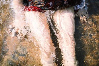 Low section of person swimming in river