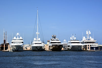 Yachts in port against clear blue sky