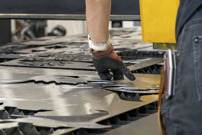 Low section of man standing in factory