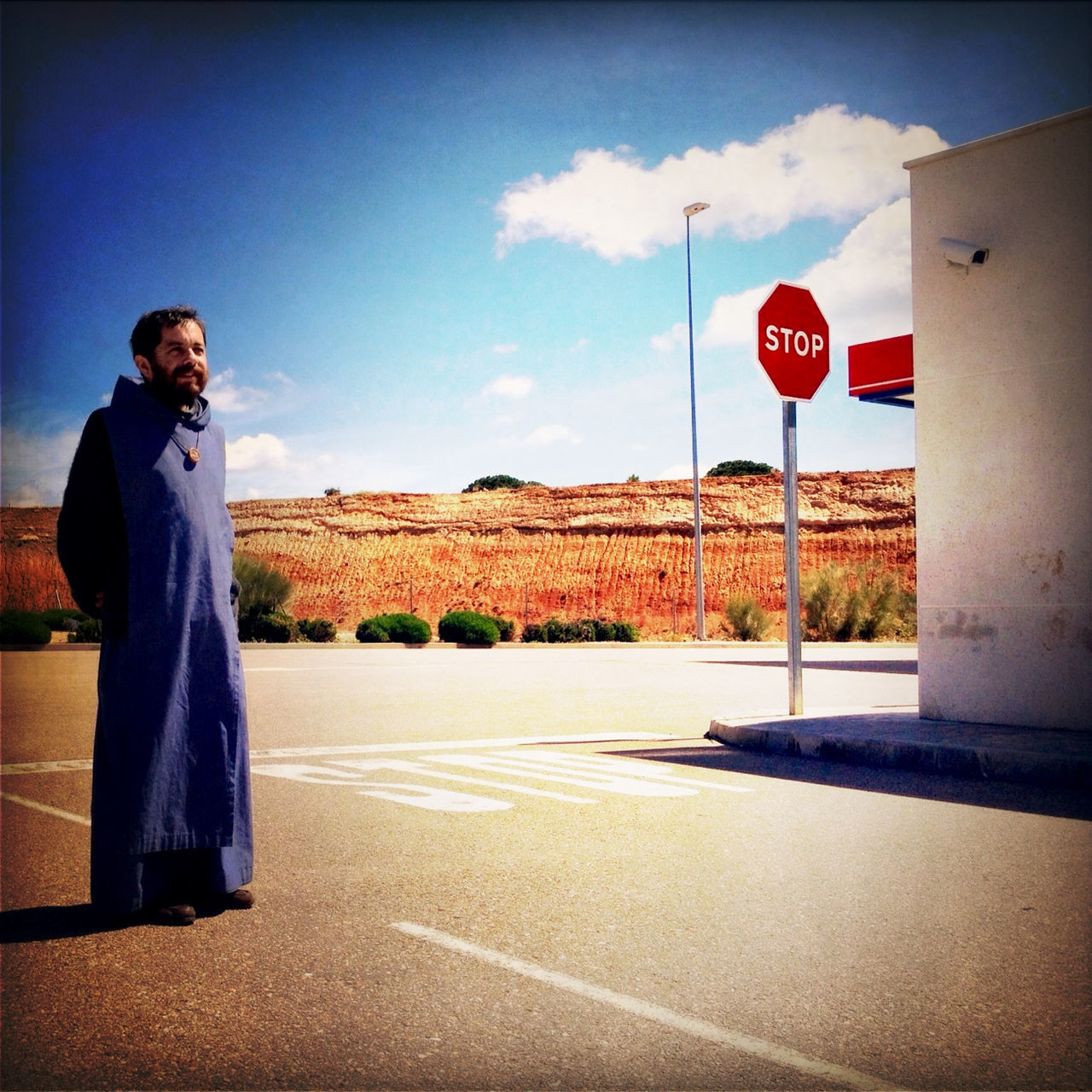 sky, road sign, communication, lifestyles, road, text, sign, western script, standing, transportation, leisure activity, cloud, cloud - sky, men, casual clothing, full length, street, blue