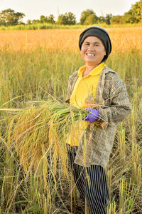 Portrait of a smiling young woman standing in field