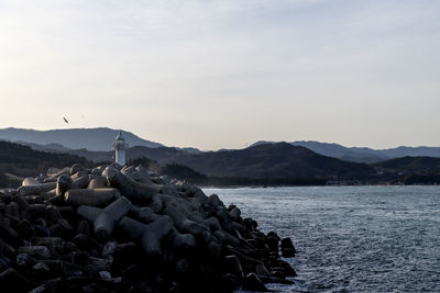 Stack of rocks by sea against sky