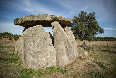 Rock formations on field against sky