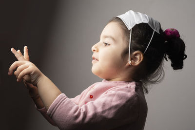 Side view portrait of a girl against gray background