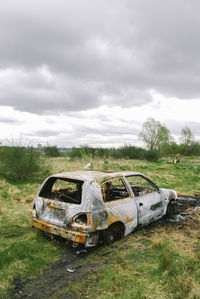 Abandoned truck on field against sky