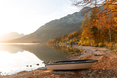 Autumn scene with a lake and colourful mountains on the background