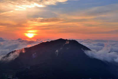 Scenic view of mountains against orange sky