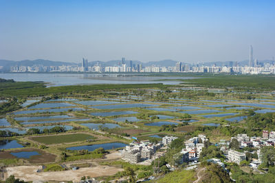 Scenic view of river by city against sky