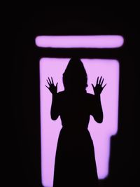 Silhouette of woman with arms raised