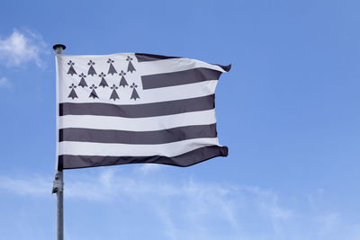 Low angle view of flag against blue sky