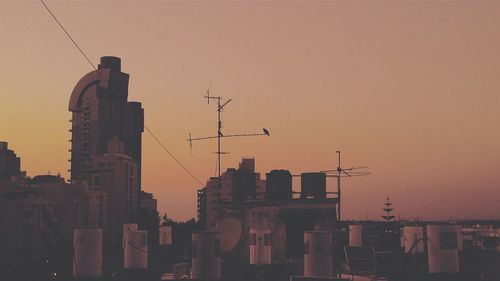 Low angle view of buildings against clear sky at dusk