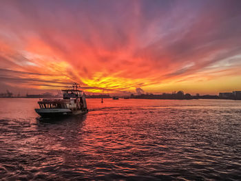 Scenic view of sea against cloudy sky during sunset