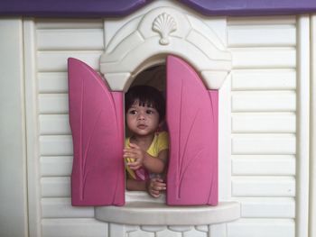 Close-up of cute baby girl in pink indoors