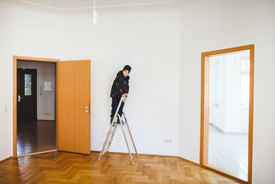 Boy on ladder at home