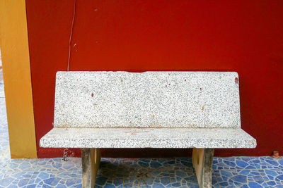 Close-up of empty chair on table against wall