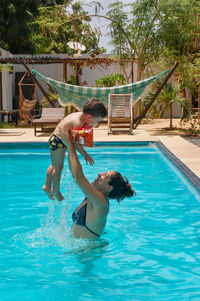 Mother and son enjoying in swimming pool