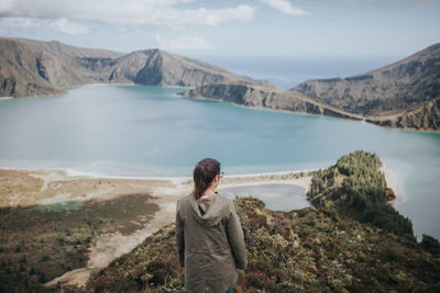 Rear view of woman on mountain looking at lake