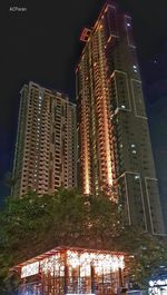 Low angle view of illuminated buildings against sky at night