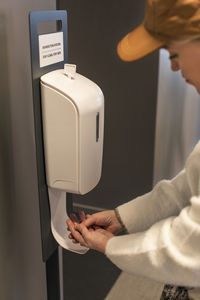 Woman using hand sanitizer dispenser
