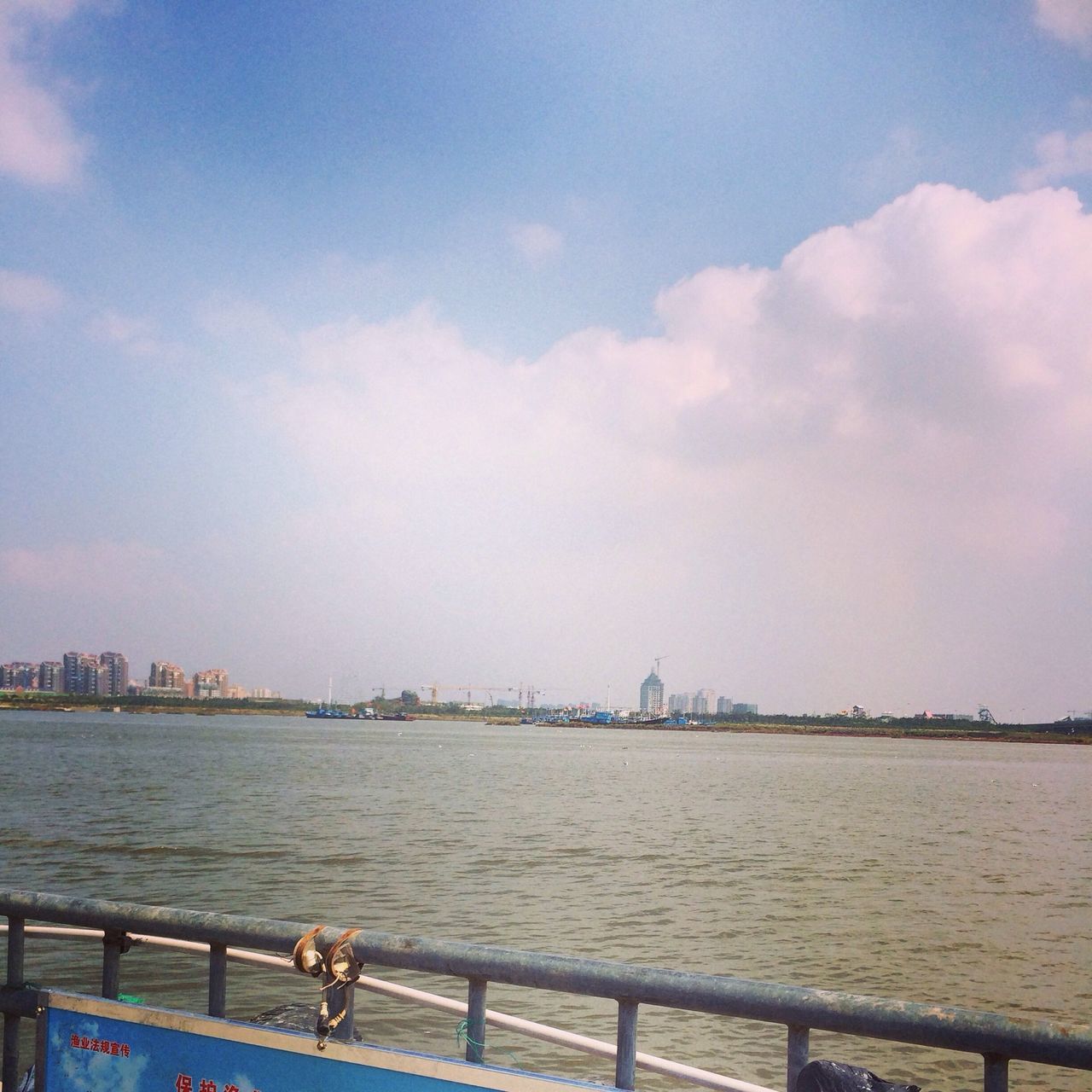 water, sky, sea, built structure, architecture, building exterior, city, railing, cityscape, cloud - sky, river, cloud, nature, urban skyline, outdoors, rippled, nautical vessel, day, blue, cloudy