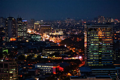 High angle view of illuminated buildings against sky at night