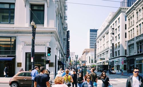 People walking on city street amidst buildings